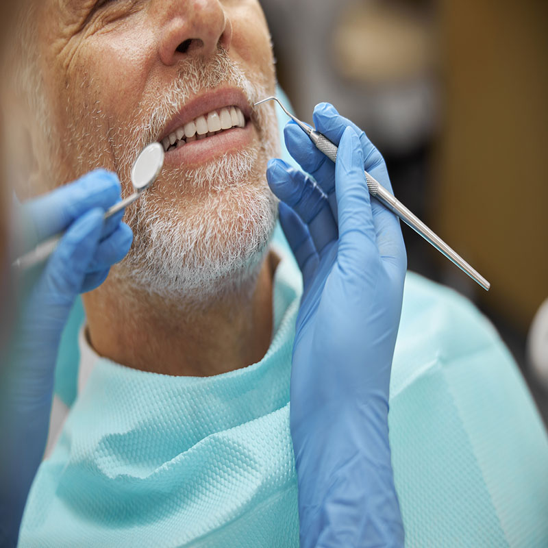 calm elderly man smiling during dental examination 2023 11 27 05 02 39 utc